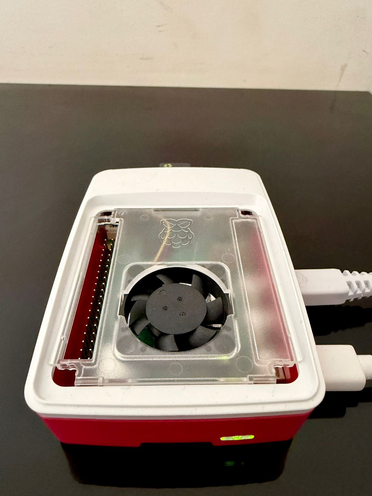 Friday's Raspberry Pi 5 - a small red and white board with a fan, sitting on a desk in Bangalore